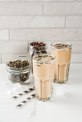 Asian, Malaysian traditional drink Yuenyeung from tea, coffee, milk, with ice cubes, on white kitchen background copy space
