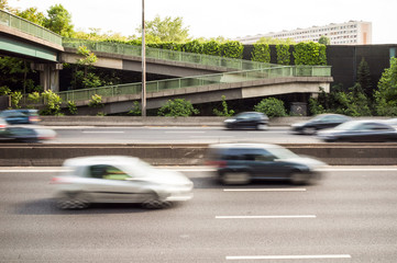 View of the A4 highway in the suburbs of Paris with speeding cars passing under a pedestrian...