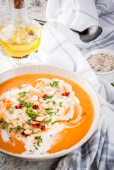 Trendy vegan food, Sweet Potato Detox Soup with coconut milk, dried tomatoes, peanuts and herbs, on grey stone table copy space