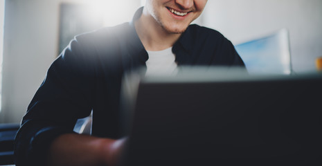 Cropped image of happy smiling businessman working in office on laptop, smiling handsome man using portable computer in coffee shop, cheerful male freelancer working from home