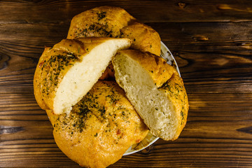 Plate with italian bun ciabatta on wooden table. Top view
