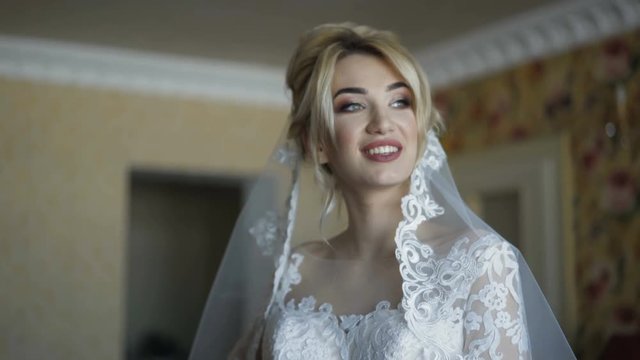 Gorgeous bride smiles and easy poses at camera indoors 4K