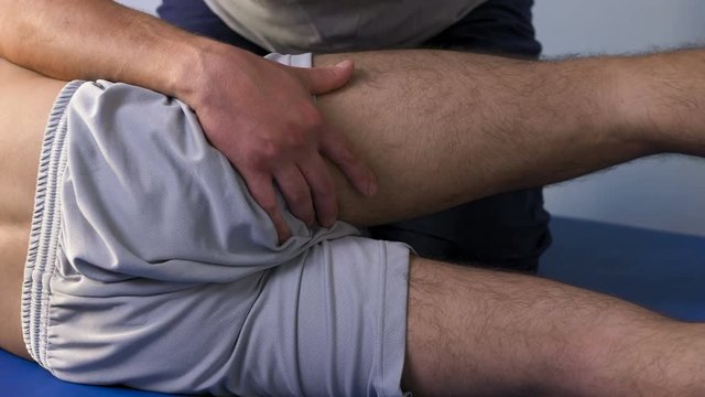 physiotherapist working on the patient's leg and knee