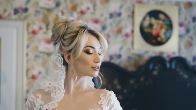 Pretty bride poses in bedroom for photosession. 4K
