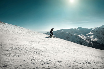 Nice mountains view at sunny day with skiers under blue sky with