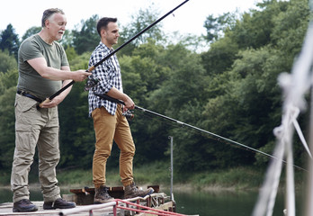 Serious male friends fishing together