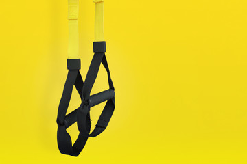 Obraz premium Training loop equipment. Black loop functional training equipment on yellow background. Sport accessories. Fitness and Gym workout items for Healthy.