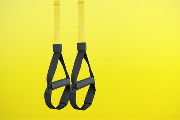 Trx training loop equipment. Black trx loop functional training equipment on yellow background. Sport accessories. Fitness and Gym workout items for Healthy.