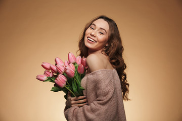Excited beautiful young woman holding tulips flowers