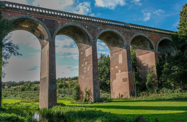 Railway viaduct in Eynesford, Kent with blue sky.  Shot looking up at the brick arches. 