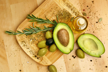 Food Ingredients. Olive Oil With Olives And Avocado On Table