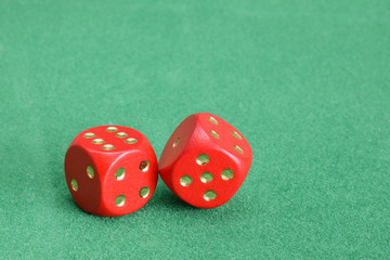 Red dice with golden points on green velvet table