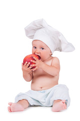 A small child is eating a big peach in a chef suit on a white background.