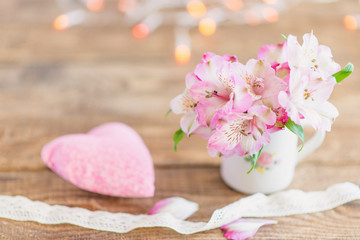 Fototapeta na wymiar bouquet of flowers in a mug with a plush heart
