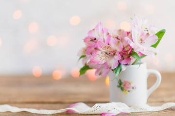 bouquet of flowers in a white mug with a white ribbon
