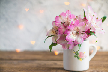 A bouquet of flowers stands in a white mug