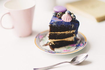 a piece of festive lilac cake with berries on a plate