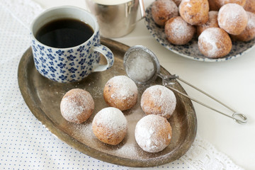 Vanilla krapfen doghnut with coffee. Rustic style.