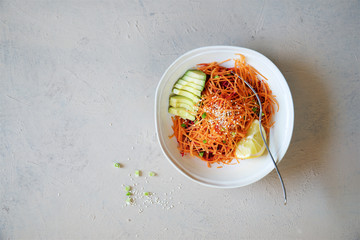 Detox carrot salad with apple, beetroot and avocado. Light background, top view
