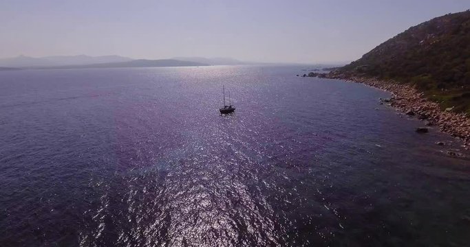 Aerial, a lonely sailing ship in a beautiful bay with crystalline water