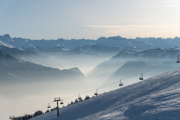 ski resort with ski slopes and lifts and a great view on a sunny winter day in the Alps - obrazy, fototapety, plakaty