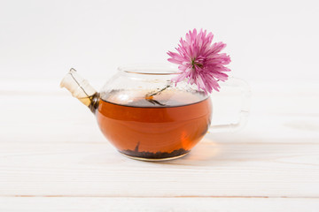 glass teapot with black tea and flower.white background.