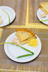children stuff and decorate pancakes with jam and powder their own hands