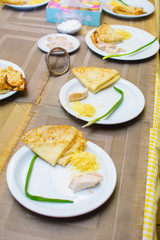 children stuff and decorate pancakes with jam and powder their own hands