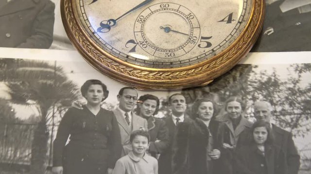 Old family photos from the 1950s and ancient objects with clock that marks the fast time