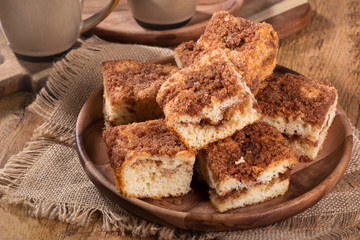 Pile of cinnamon swirl coffee cake on a wooden plate