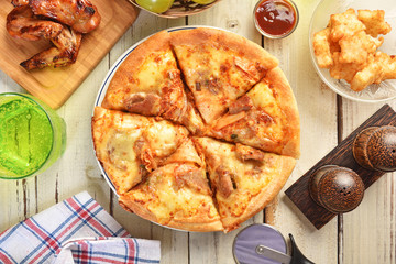 Fresh pizza with kimchi, cheese and pork on wooden table.
