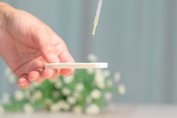 focus on the hand hold the pregnancy test pad while drop the urine on test pad