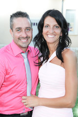 cheerful woman in pink dress with man ready for party