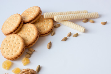 cookies, wafer rolls and nuts on white table