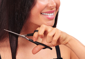 Smiling woman cutting her hair with scissors, isolated on white background