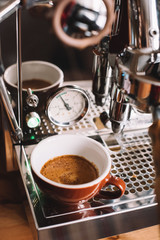 VORONEZH/RUSSIA-02.05.2018: Delicious fresh morning espresso coffee with a beautiful crema in thick brown Acme cappuccino cup standing on a drip tray of a Rocket r58 v2 customized espresso machine - 195165068