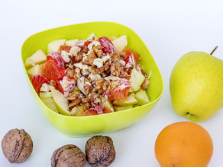 Fruit bowl with sliced apples oranges and nuts