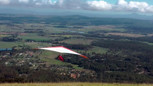 Hang gliders take off from a mountain top