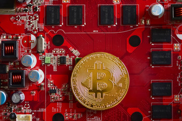 Bitcoin - cryptocurrency and worldwide payment system. First decentralized digital currency, as the system works without a central bank or single administrator. Bitcoin on a red computer graphic card