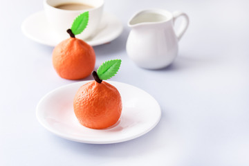 Beautiful Small Mousse Cake in Shape of Citrus Mandarin Tasty Modern Dessert Pastry White Blue Background Cup of Coffee