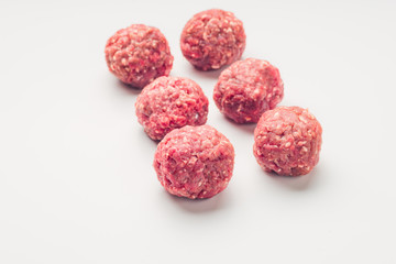 Meat balls from raw beef force-meat on a white