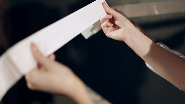 Electrocardiogram, ecg in hand, palm of a doctor. Clinic cardiology heart rhythm and pulse test closeup. Cardiogram printout.