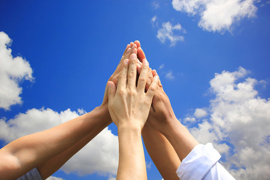 Meeting teamwork concept,Friendship,Group people with stack of hands showing unity on blue sky background
