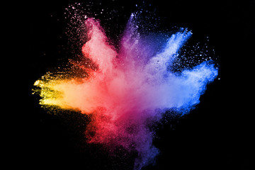 Abstract multicolored powder explosion on black background.  Freeze motion of color dust  particles...