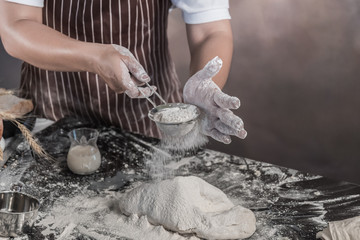 Man preparing buns at table in bakery