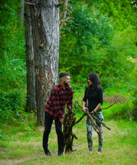 Man and woman collecting firewood in forest.