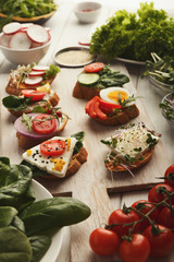 Variety of healthy organic vegetarian sandwiches on white kitchen table