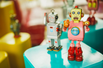 Old vintage pink robot toy on a color blurry background. Robotics and design of the past.