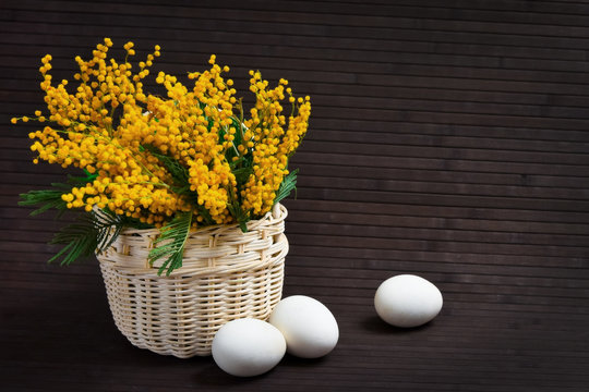 Basket of mimosa with Easter eggs