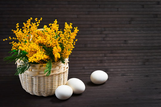 Basket of mimosa with Easter eggs